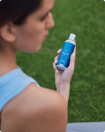 A woman holding the bottle fo Relief Oil and looking sideways
